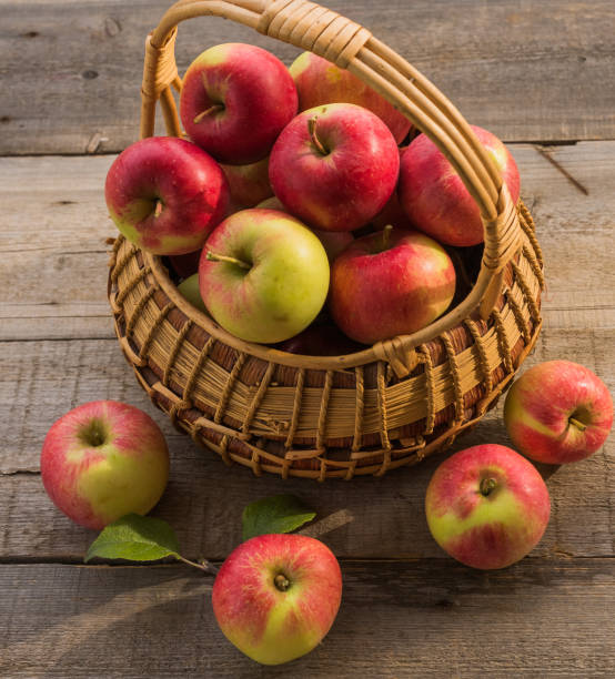 istock The basket with ripe apples  on old wooden table background. 1038252726
