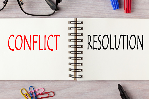 Conflict vs Resolution written on notebook with marker pen. Business Concept.