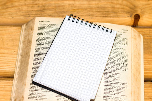 istock notebook on open old book in wooden table 1038313828