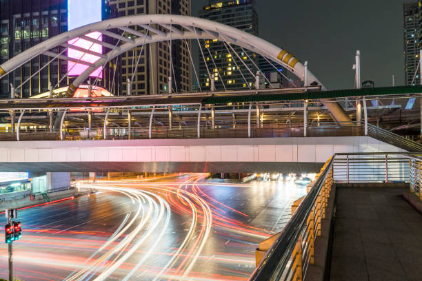 Skywalk bridge with car head and rear lights motion with slow speed shutter at intersection Skywalk bridge with car head and rear lights motion with slow speed shutter at intersection long shutter speed stock pictures, royalty-free photos & images