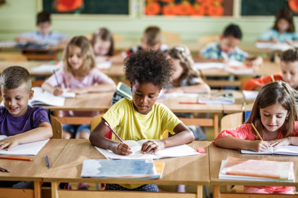 istock Large group of school kids writing a test on a class in the classroom. 1038332258