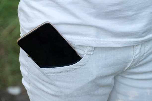 istock Mobile phone in the pocket of white pants. 1038363540