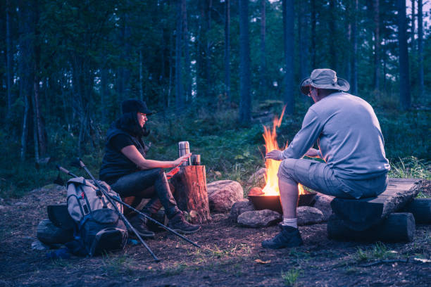 istock man and women in the forest by the campfire 1038371942