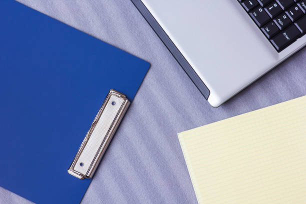 istock Laptop and notebook on a soft striped plaid, close-up 1038372056
