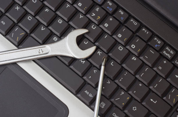 istock A wrench and a screwdriver on the laptop keyboard 1038372066