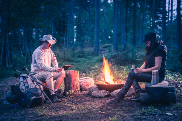 istock man and women in the forest by the campfire 1038372072