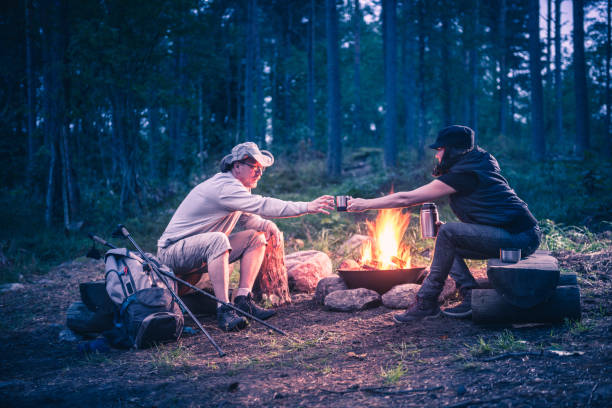 istock man and women in the forest by the campfire 1038372716