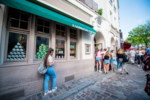 foule de touristes entrant dans le café de starbucks sur montmartre, paris - starbucks women walking restaurant photos et images de collection