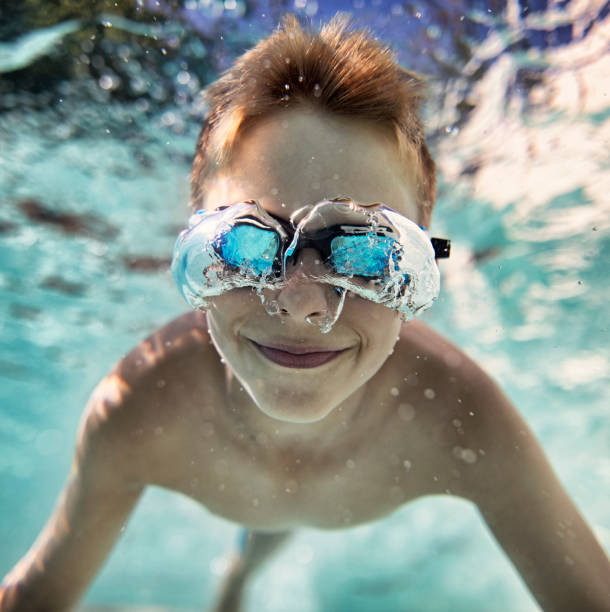 istock Little boy swimming underwater in pool 1038377018