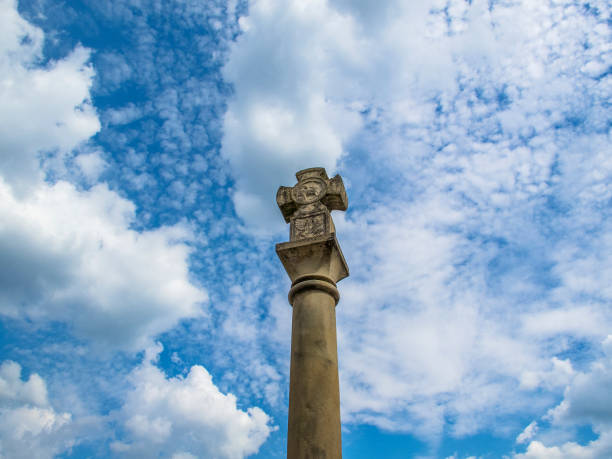 The justice cross against a beautiful cloudy sky in Echternach, the oldest city of Luxembourg The cross of justice on the Market Place against a beautiful cloudy sky in Echternach, the oldest city of Luxembourg agnus dei stock pictures, royalty-free photos & images