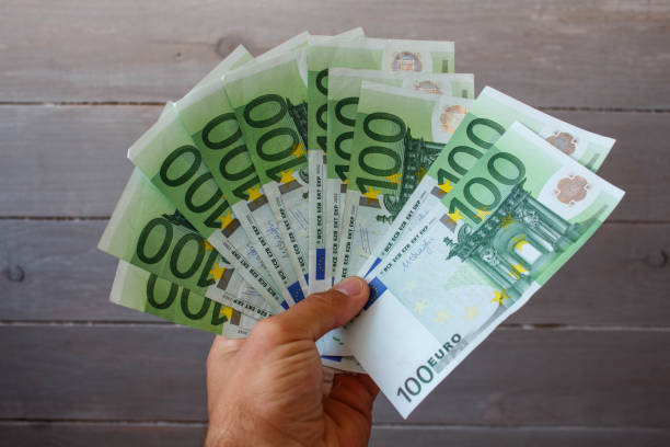 istock a money in a hand on a wooden background 1038383692