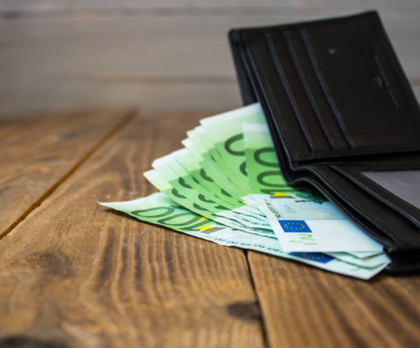 istock a wallet with money on a wooden background 1038386310