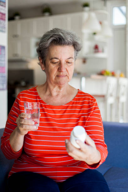 istock senior woman taking pills 1038396278