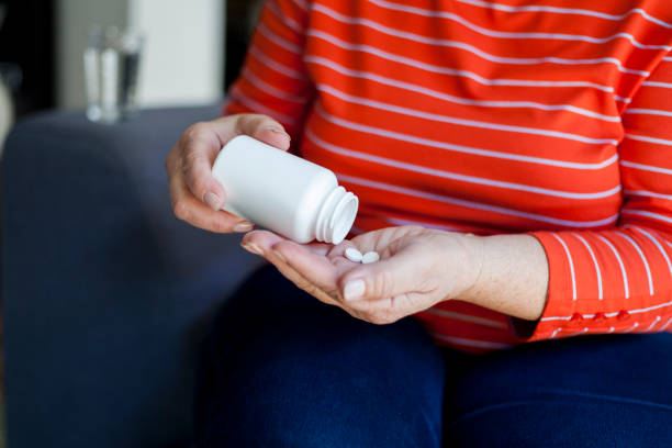 istock senior woman taking pills 1038401486