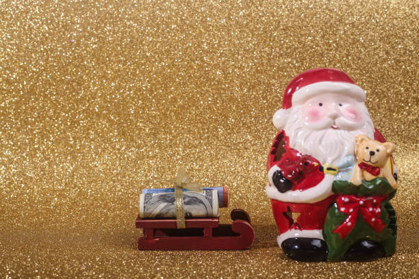 Christmas ball on gold glitters Christmas money gift on abstract gold glitters bokeh background euro bill in a christmas ornament stock pictures, royalty-free photos & images