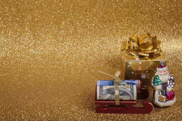 Christmas ball on gold glitters Christmas money gift on abstract gold glitters bokeh background euro bill in a christmas ornament stock pictures, royalty-free photos & images