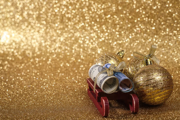 Christmas ball on gold glitters Christmas money gift on abstract gold glitters bokeh background euro bill in a christmas ornament stock pictures, royalty-free photos & images