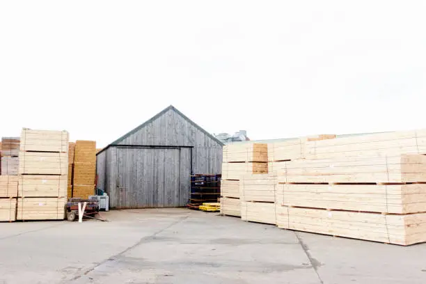 Stacked wood stored at sawmill for biomass fuel uk