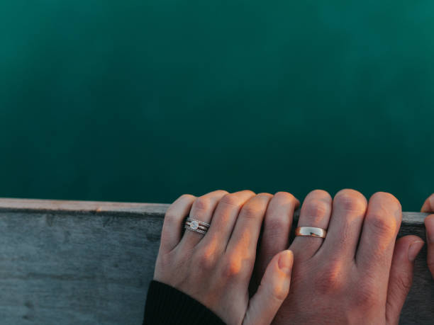 To Have and To Hold A married couple hold hands on a pier railing above the beautiful Gulf of Mexico. honeymoon photos stock pictures, royalty-free photos & images