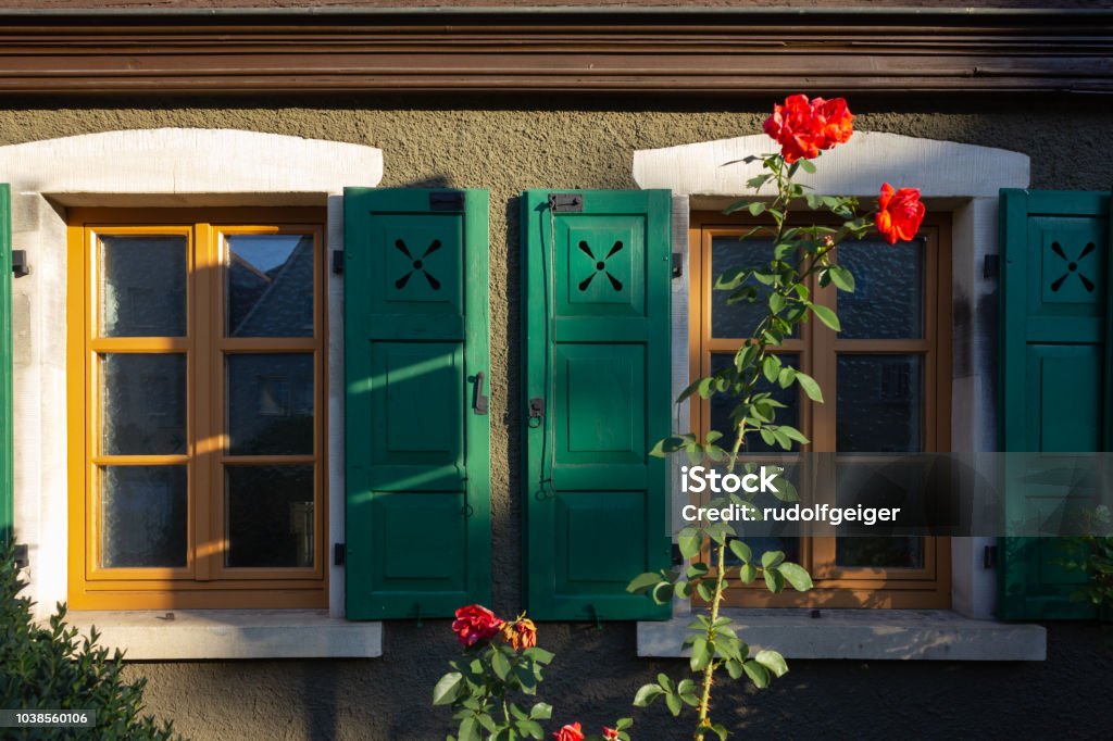 rose ed sulla facciata quadro con persiane verde finestra - Foto stock royalty-free di Antico - Condizione