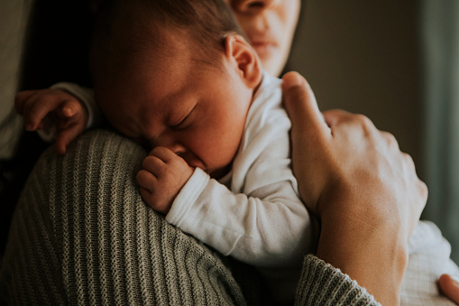 Mother holding her baby indoors