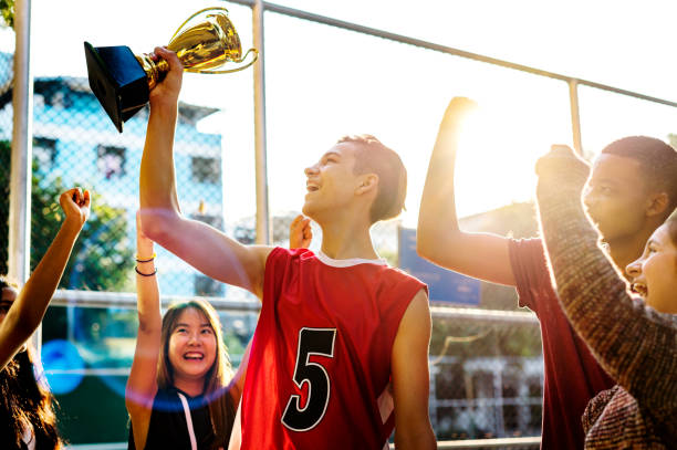 group of teenagers cheering with trophy victory and teamwork concept - child basketball sport education imagens e fotografias de stock