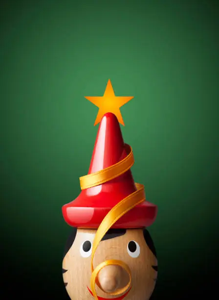 Photo of Christmas Pinocchio. Red hat like Christmas tree.
