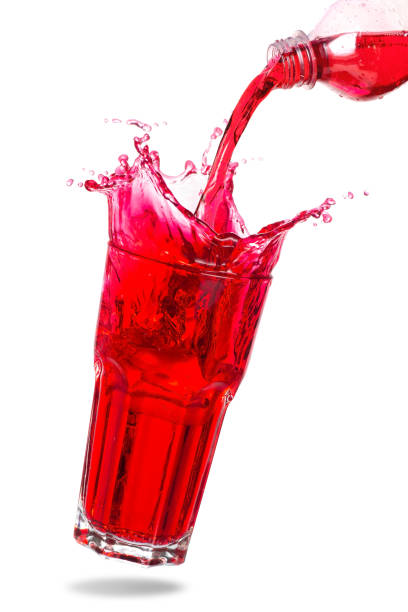 Red cocktail splashing Pouring red soda from bottle into glass with splashing isolated white background. red drink stock pictures, royalty-free photos & images