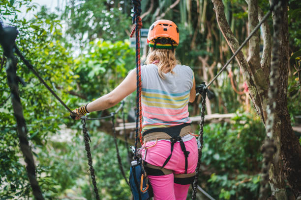 rückansicht einer frau zip-futter in der natur. - ziplining zip line outdoors zip lining stock-fotos und bilder