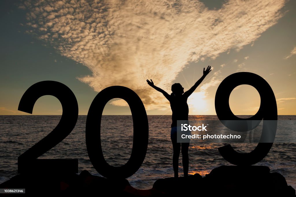 Silueta de una mujer de pie en el año 2019 en la colina al amanecer - Foto de stock de 2019 libre de derechos
