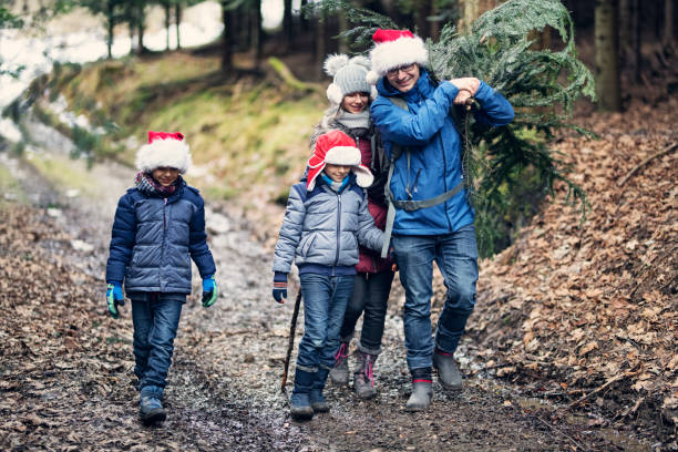 istock Father with kids carrying some Christmas tree branches 1038636178