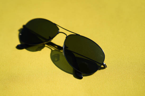 istock Men's sun glasses on yellow background 1038636488