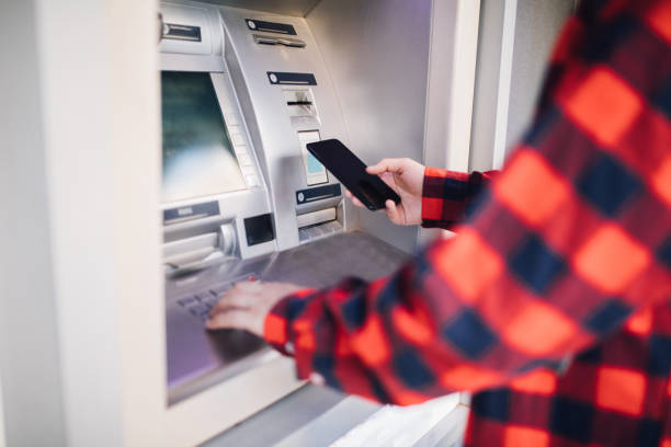 istock Withdrawing money atm with mobile phone 1038639992