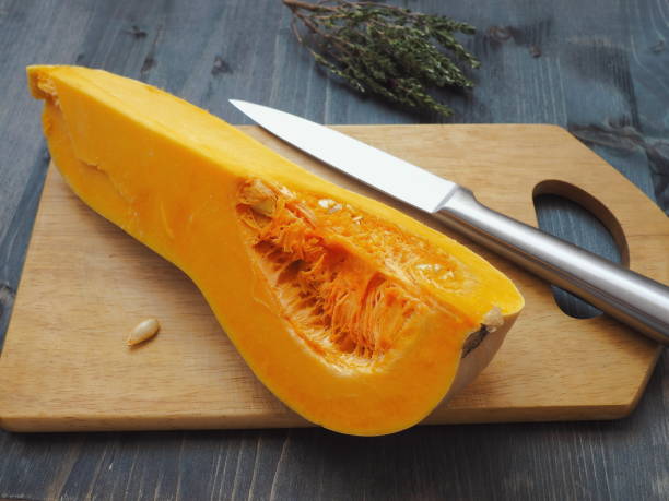 istock Bottle shaped pumpkin quartered upon cutting board. High view. 1038640180