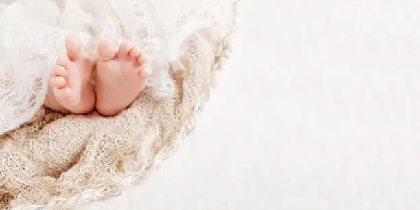 Photo of Newborn baby feet on knitted plaid. Closeup picture. Copyspace