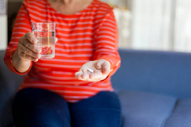 istock senior woman taking pills 1038646748