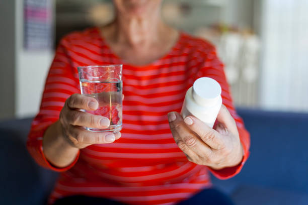 istock senior woman taking pills 1038647332