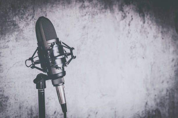 istock old black and white condenser microphone on wall background with copy space 1038649542