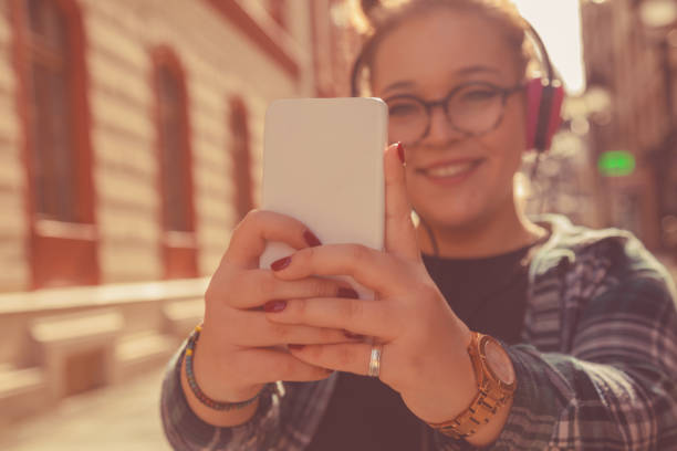 istock Beautiful woman listening music on headphone while doing selfie. 1038652676