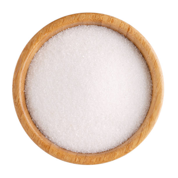 istock White refined sugar in wooden bowl isolated on white. Top view. 1038653964