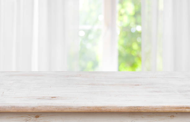 istock Wooden empty board in front of blurred curtained window background 1038658314