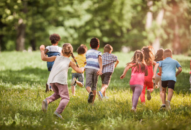 istock Back view of kids having fun while running in springtime. 1038666634