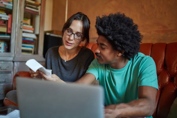 istock Multi-ethnic couple discussing bills over laptop 1038683972