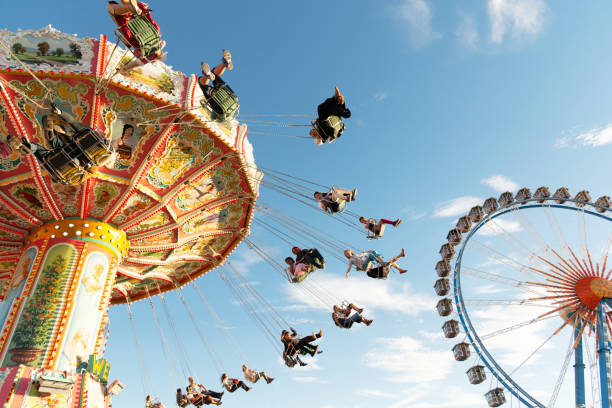 Munich, Germany - September 29, 2016: People enjoy the ride on a carousel during a sunny afternoon at the Oktoberfest in Munich (Germany). The Oktoberfest is the biggest beer festival of the world with over 6 million visitors each year.