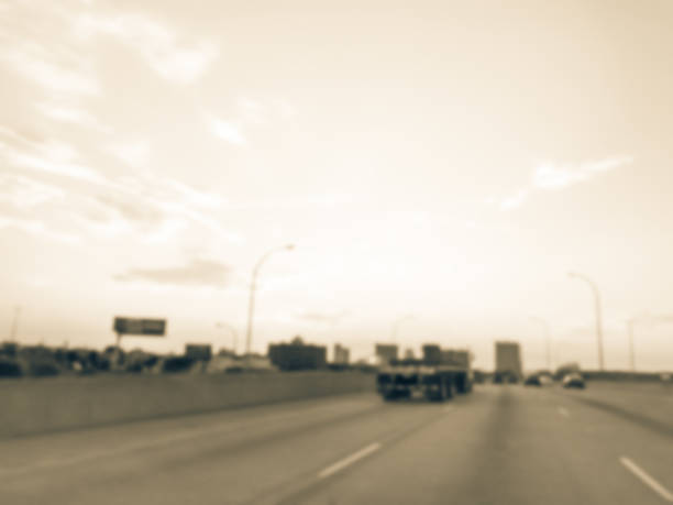 istock Blurry background long vehicles commute on interstate highway at sunrise 1038684604