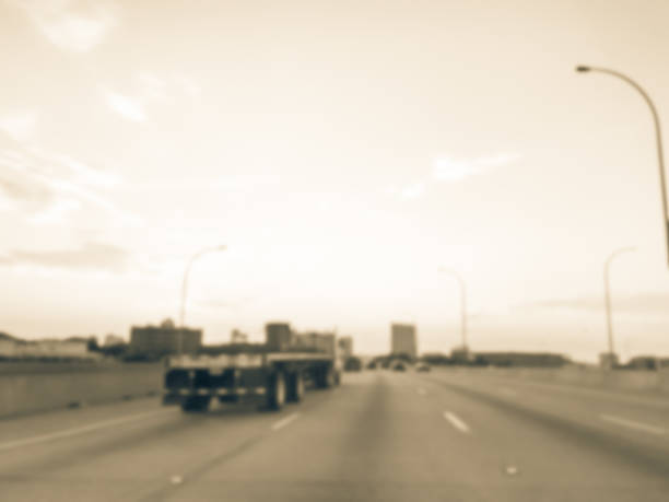 istock Blurry background long vehicles commute on interstate highway at sunrise 1038684676