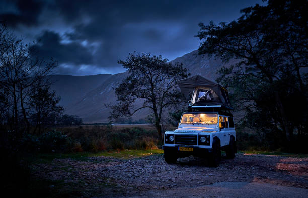 Land Rover defender camping with a tent on the roof Land Rover defender camping with a tent on the roof near lake, Glen Etive early in the morning glen etive photos stock pictures, royalty-free photos & images