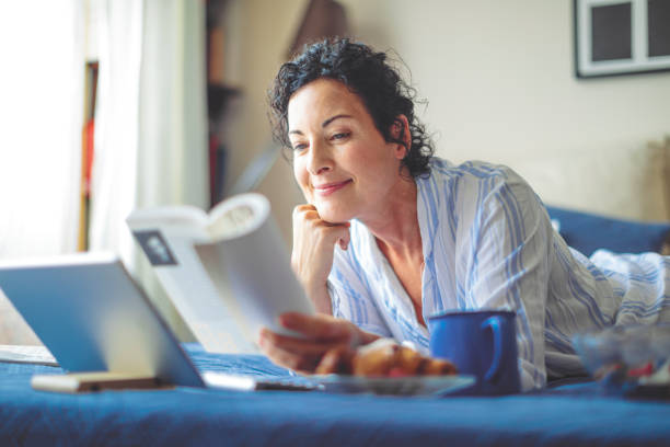 istock Mature woman is getting up and reading a book 1038703876