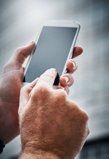 istock Male hand tapping blank phone screen by office building 1038722016