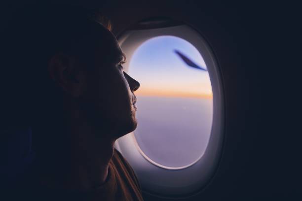 mann mit dem flugzeug reisen - fensterplatz fahrzeugsitz stock-fotos und bilder